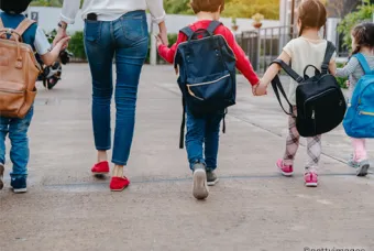 Enfants marchant main dans la main avec un adulte